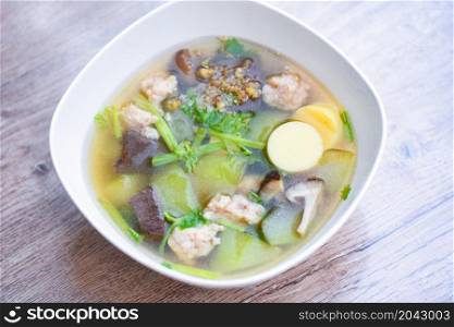 Tofu Soup bolw with winter melon vegetable eggs tofu slice meat ball and minced pork with celery, Clear soup blood pork thai healthy food asian on dark background, top view