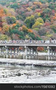 togetsukyo bridge with colorful leaves mountains and Katsura river in Arashiyama, landmark and popular for tourists attractions in Kyoto, Japan. Fall Autumn season, Vacation,holiday and Sightseeing