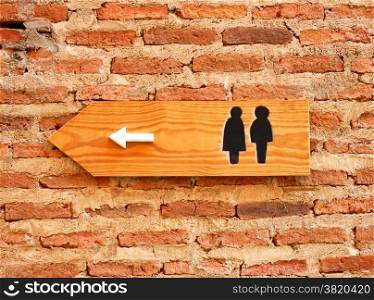 Toilet sign and direction on brick wall