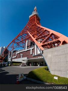 Tokyo, Japan - NOV 12, 2017: Tokyo tower in close up view with tourist group taking photo near tokyo tower entrance in Tokyo, Japan.