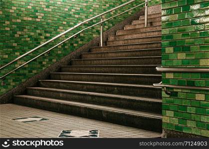 Tokyo subway stairway to station underground passage with retro green tiles wall