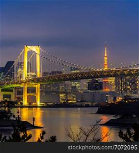 Tokyo Sunset with Tokyo tower and Rainbow bridge with Tokyo cityscape in background from Odaiba Japan.