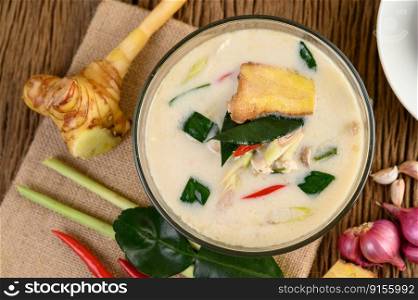 Tom Kha Kai in a bowl with kaffir lime leaves, lemongrass, red onion, galangal and chilli.