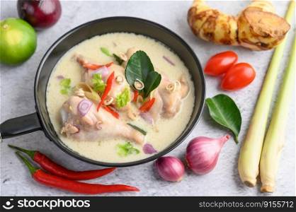 Tom Kha Kai in a pan frying with kaffir lime leaves, lemongrass, red onion, galangal and chilli.Selective focus.