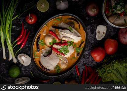 Tom yum chicken with chili, coriander, dried chili, kaffir lime leaves, mushroom and lemongrass in a bowl