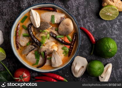 Tom yum chicken with chili, coriander, dried chili, kaffir lime leaves, mushroom and lemongrass in a bowl