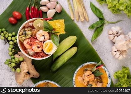 Tom Yum noodle with shrimp and boiled egg, accompanied by lime, cucumber, basil, eggplant and garlic.