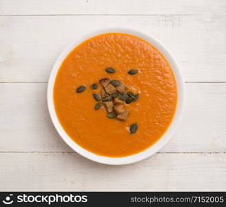 Tomato cream soup on a wooden table