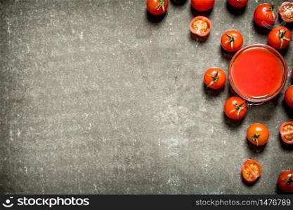 Tomato juice and whole tomatoes. Wet stone background. . Tomato juice and whole tomatoes.