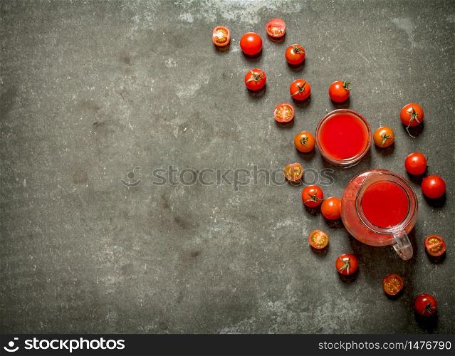Tomato juice and whole tomatoes. Wet stone background. . Tomato juice and whole tomatoes.