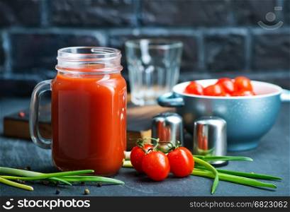 tomato juice in glass bank and on a table