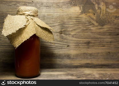 Tomato juice in glass bottle on wooden background