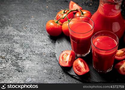 Tomato juice on a stone board. On a black background. High quality photo. Tomato juice on a stone board.