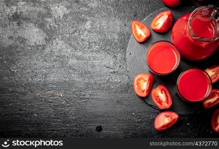 Tomato juice on a stone board. On a black background. High quality photo. Tomato juice on a stone board.