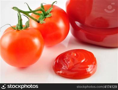 tomato ketchup and fresh tomatoes , close up