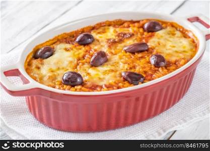 Tomato risotto with mozzarella and olives in baking dish