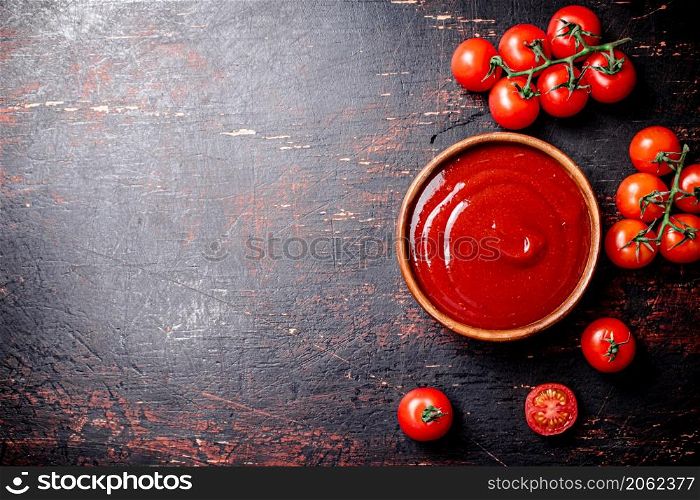Tomato sauce in a wooden plate. On the dark background. High quality photo. Tomato sauce in a wooden plate.