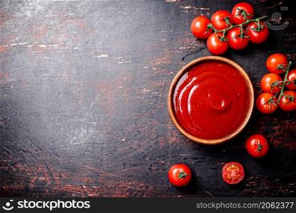 Tomato sauce in a wooden plate. On the dark background. High quality photo. Tomato sauce in a wooden plate.