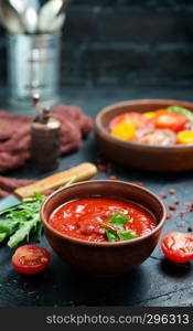 tomato sauce in bowl and fresh tomato on a table