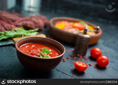 tomato sauce in bowl and fresh tomato on a table