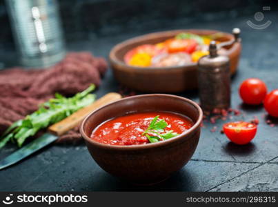 tomato sauce in bowl and fresh tomato on a table