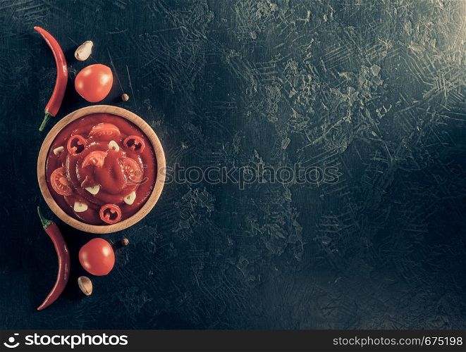 tomato sauce in bowl on black background table texture, top view