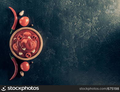 tomato sauce in bowl on black background table texture, top view