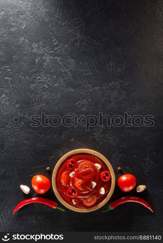 tomato sauce in bowl on black background texture