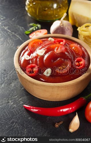 tomato sauce in bowl on black background texture