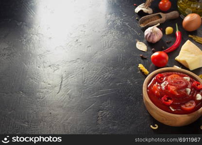 tomato sauce in bowl on black background texture