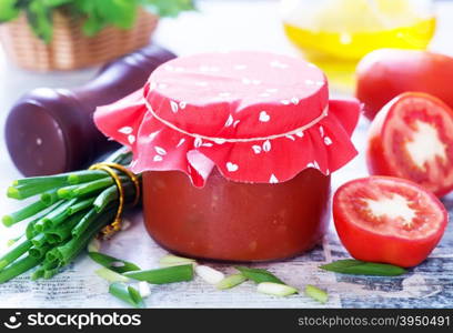 tomato sauce in glass bank and on a table