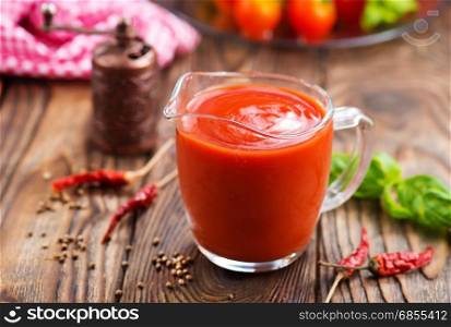 tomato sauce in glass jug and on a table