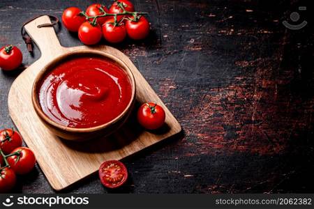 Tomato sauce on a wooden cutting board. Against a dark background. High quality photo. . Tomato sauce on a wooden cutting board.