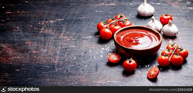 Tomato sauce with spices and garlic. Against a dark background. High quality photo. Tomato sauce with spices and garlic.