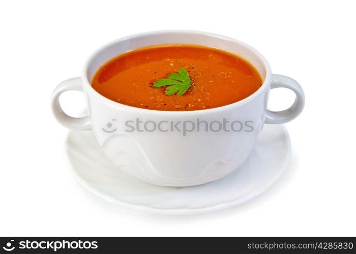 Tomato soup in a white bowl with parsley on a plate isolated on white background