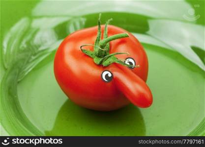tomato with a nose lying on the green dish
