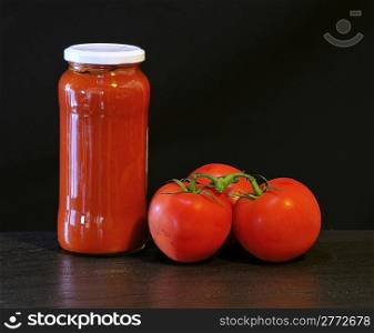 Tomato with sauce and isolated black background.