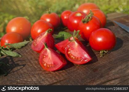 Tomato with slice on rustic wooden background. Fresh cut tomato on wooden table. Sliced tomatoes on wooden table. Half tomatoes on wooden background