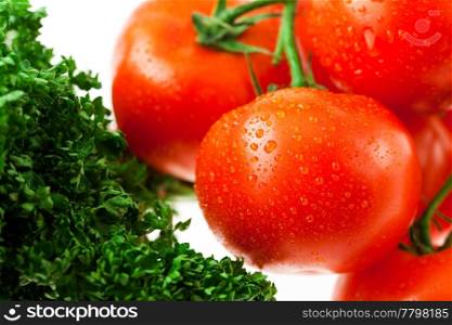tomatoes and greens with water drops in a glass