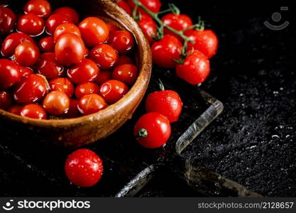 Tomatoes for marinating in a wooden plate. On a black background. High quality photo. Tomatoes for marinating in a wooden plate.