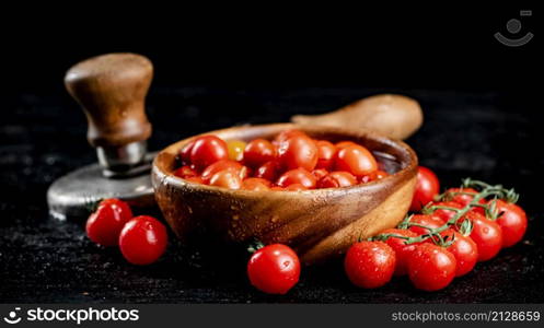 Tomatoes for marinating in a wooden plate. On a black background. High quality photo. Tomatoes for marinating in a wooden plate.