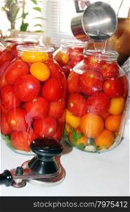 tomatoes in the jars prepared for preservation. red tasty tomatos in jars which are been flooding by boiling water prepared for preservation