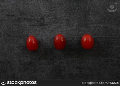 Tomatoes on dark rock background