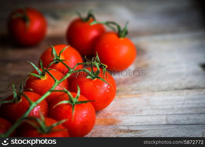 Tomatoes on rustic wooden background