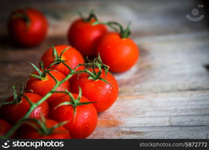 Tomatoes on rustic wooden background