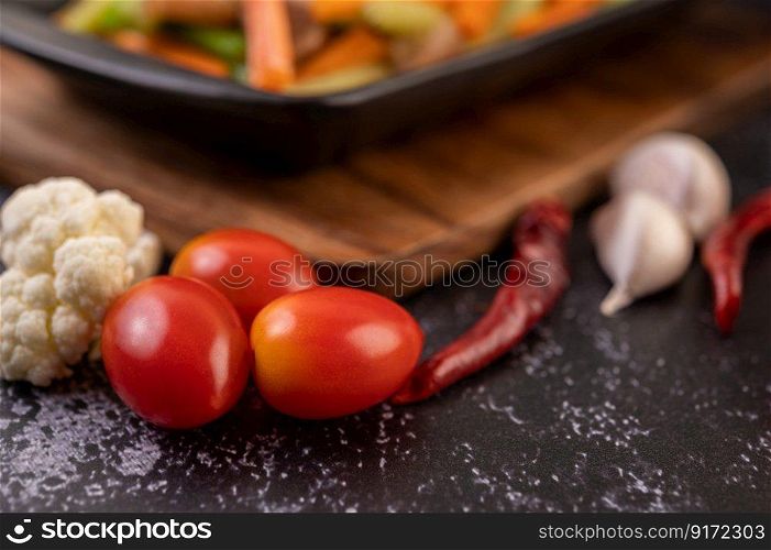 Tomatoes on the ground with peppers and garlic.