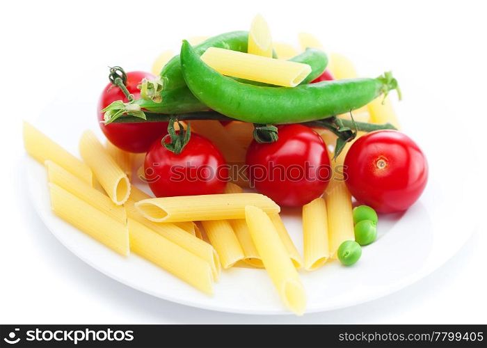 tomatoes, peas, pasta on a plate isolated on white