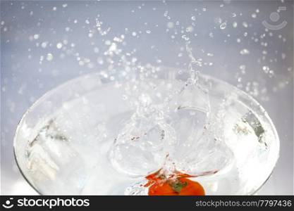 tomatoes with splashes of water in a glass bowl