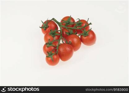 tomatoes with water drops and stems in a glassware on a white background. tomatoes in a glass bowl