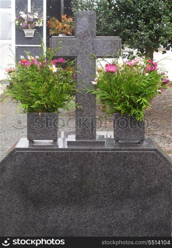 Tomb in a cemetery in Spain with a large granite cross&#xA;&#xA;